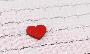 Czerwone serduszko na tle zapisu EKG. Może symbolizować troskę o serce i świadomość objawów wysokiego ciśnienia.