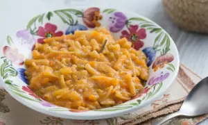 Un plat réconfortant de pâtes italiennes avec de la pomme de terre et des légumes, servi dans un bol fleuri.