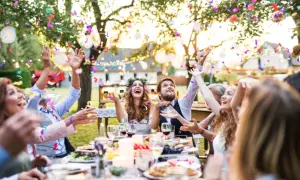 Fröhliche Gäste werfen Konfetti bei einer Gartenparty. Tolle **Gartenparty Ideen** für unvergessliche Momente mit Freunden und Familie.