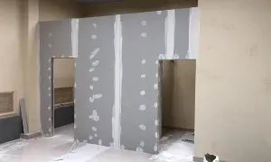 Ściana z karton gipsu w trakcie budowy z otworami drzwiowymi.