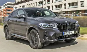 Eleganckie BMW X4 w kolorze grafitowym pędzi ulicą, za kierownicą siedzi mężczyzna.