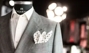 Elegancka brustasza w kratę z białą koszulą i wzorzystą poszetką.