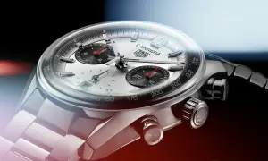 Primer plano de un reloj TAG Heuer Carrera. El cristal mineral se raya levemente, mostrando la esfera plateada y los sub-diales negros.