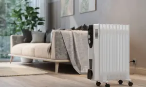 Radiador de aceite blanco con ruedas, listo para calentar la sala. Control de temperatura visible, ideal para un consumo eficiente.