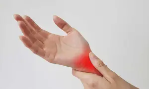 Dłoń z zaczerwienionym obszarem bólu, wskazującym na skręcenie nadgarstka.
