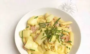 Cremige Spargel Carbonara mit Penne, Schinken und frischem Schnittlauch garniert. Ein Genuss für jeden Gaumen!