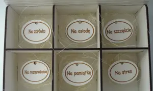 Drewniane pudełko na 40 urodziny z sześcioma przegródkami, każda z owalnym medalionem z napisem: "Na zdrowie", "Na osłodę", "Na szczęście", "Na rozmnożenie", "Na pamiątkę", "Na stres".