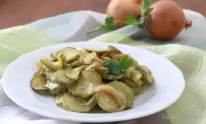 Zucchine in padella con cipolla, un contorno semplice e gustoso, guarnito con prezzemolo fresco.
