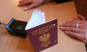 Polski paszport obok skanera linii papilarnych. Dokument z godłem Polski, gotowy do podróży.