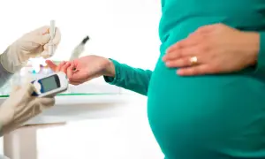 Gravid kvinna får blodprov för glukosbelastning. Läkare kontrollerar blodsockret, eventuella biverkningar kan uppstå.