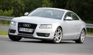 Srebrne Audi A5 z 2006 roku na drodze, z widocznym kierowcą.