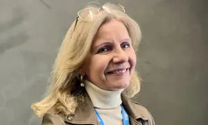 Helene Barnekow ler mot kameran, med glasögon på huvudet och en beige polotröja under en brun jacka.