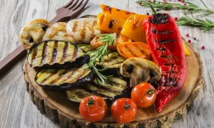 Pyszne przekąski na grilla: grillowany bakłażan, papryka, pieczarki, pomidorki i cebula, udekorowane rozmarynem.
