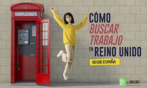 Mujer salta de alegría junto a una cabina telefónica roja en Londres, celebrando cómo buscar trabajo en el Reino Unido desde España.