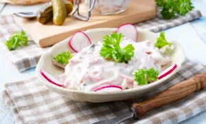 Leckerer Fleischsalat, garniert mit Radieschen und Petersilie. Ein einfaches Rezept für den perfekten Fleischsalat.