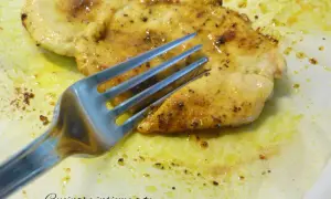 Un succulento petto di pollo in padella morbido, dorato e speziato, pronto per essere gustato con una forchetta.