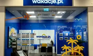 Witryna biura podróży Wakacje.pl z logo, wystawami ofert i dekoracjami wakacyjnymi.