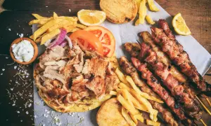 Zapiekanka z kurczakiem gyros, frytkami, pitą, sosami i szaszłykami z kurczaka.
