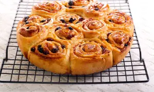 Dolci pittanchiusa dorati e lucidi, con uvetta, su una griglia.
