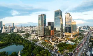 En livlig stadssilhuett i Thonglor, Bangkok, med höga skyskrapor, grönskande parker och en trafikerad motorväg.