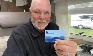 Man håller upp ett Autopass-kort för färjor, troligen för en svensk bil på resa i Norge.