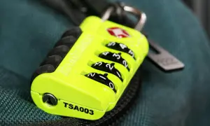 Neongrünes TSA-Schloss mit Zahlenrädern, bereit für den Koffer-Transport in die USA.