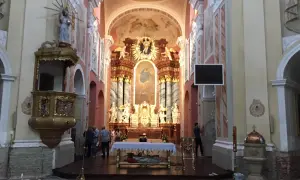 Wnętrze kościoła w Trzemesznie z ołtarzem głównym, amboną i wiernymi.