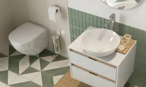 Nowoczesna łazienka z białym, wiszącym wc w rogu, umywalką nablatową i zielonymi płytkami.