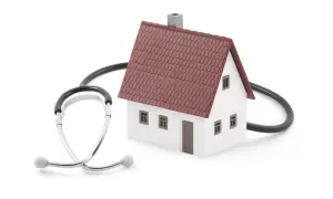 Modello di casa con uno stetoscopio avvolto attorno. Simboleggia la voltura utenze dopo rogito, assicurando che la tua nuova casa sia in salute.