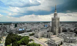 Warszawski Pałac Kultury i Nauki góruje nad miastem, ukazując swoją imponującą wysokość na tle chmur.