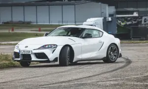 Biała Toyota GR Supra na torze, zostawiająca ślady opon.