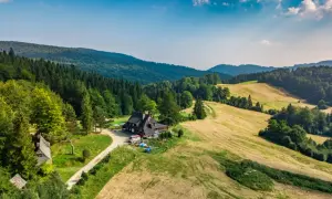 Malownicza bacówka nad Wierchomlą, gdzie trasa turystyczna prowadzi przez zielone wzgórza i lasy.