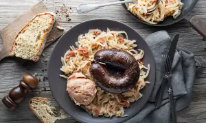 Kaszanka z grilla podana z kapustą kiszoną i chlebem. Pyszne danie, które rozgrzewa i syci.
