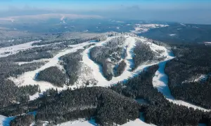 Schneebedeckte Hänge und Wälder, perfekt für einen Tag auf dem Plesivec Ski.