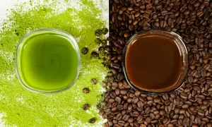 Zielony napój matcha obok ciemnej kawy, otoczone proszkiem matcha i ziarnami kawy. Wybór na poranek: matcha zamiast kawy?