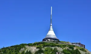 Wieża telewizyjna na górze Ještěd, jedna z głównych libereckich atrakcji, góruje nad zielonymi wzgórzami.