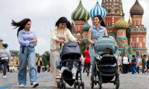 Kobiety z wózkami spacerują po Placu Czerwonym. Tłum ludzi, jak na obrazku, to tylko ułamek całej **rosja liczba ludności**.