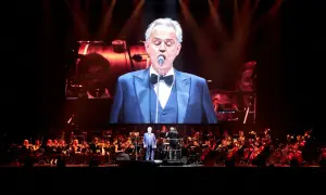 Andrea Bocelli w Gdańsku na koncercie z orkiestrą. Wokalista w garniturze na wielkim ekranie.