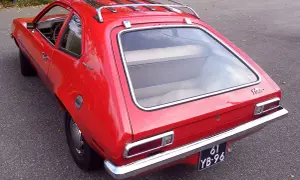 Czerwony Ford Pinto Runabout z bagażnikiem dachowym, gotowy na przygodę.