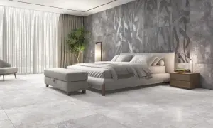 Dormitorio moderno con suelo de porcelánico rectificado, cama confortable y pared decorativa con diseño abstracto.