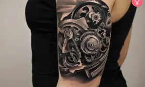 Tatuaż mechanicznej ręki z widocznymi zębatkami i elementami maszynowymi.