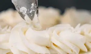Dekorowanie tortu kremem patissiere za pomocą rękawa cukierniczego.