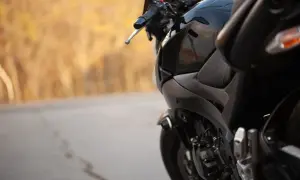 Czarny motocykl na tle jesiennego krajobrazu. Zastanawiasz się, jaki przebieg dla motocykla jest duży? Ten wygląda na gotowy na wiele przygód.