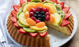 Una deliziosa crostata morbida alla frutta, con fragole, kiwi, mandarini e frutti di bosco su una base soffice e crema pasticcera.