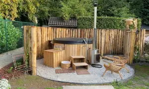 Gemütliche whirlpool ecke im garten gestalten: Holzzaun, Hot Tub, Holzofen, Sitzgelegenheiten und Holzbottich schaffen eine entspannende Oase.