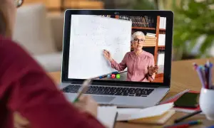 Nauczycielka tłumaczy matematykę na lekcji zdalnej na ekranie laptopa.