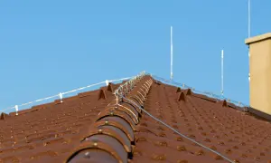 Nowy dach z brązowej dachówki, zabezpieczony nowoczesną instalacją odgromową.