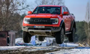 Czerwony Ford Raptor w locie nad śnieżnym terenem. Kierowcy w kabinie, a cena tego potwora budzi podziw.