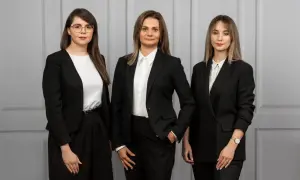 Trzy kobiety w czarnych garniturach. Zastanawiasz się, ile bierze adwokat za reprezentowanie w sądzie?