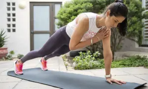 Femme en position de planche, renforçant son muscle avant bras.